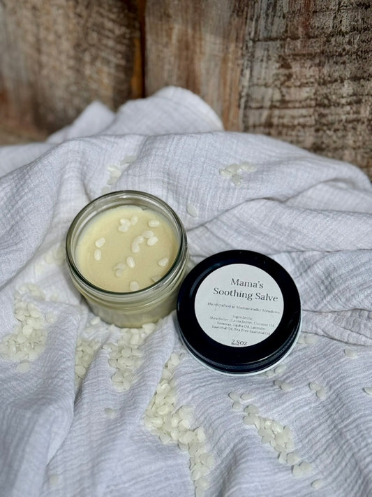 Jar of 'Mama's Soothing Salve' on a textured fabric background