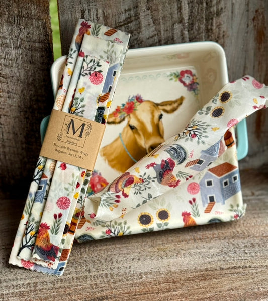Set of reusable paper wraps with farm-themed designs on a wooden surface